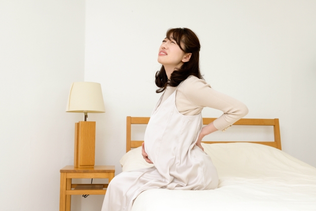 妊娠による体型の変化で腰痛に悩む妊婦